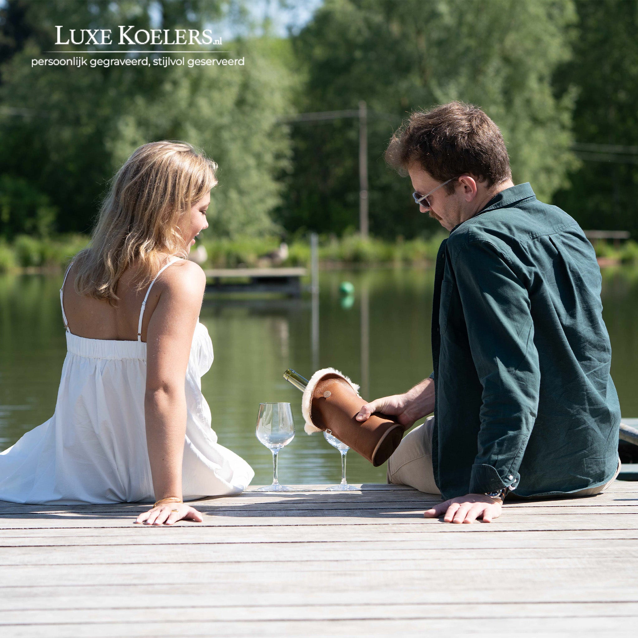 Kywie model Tulip voor wijn en normale champagne flessen.De wijnkoeler is volledig gemaakt van natuurlijke schapenvacht. Twee mensen aan de waterkant die wijn inschenken