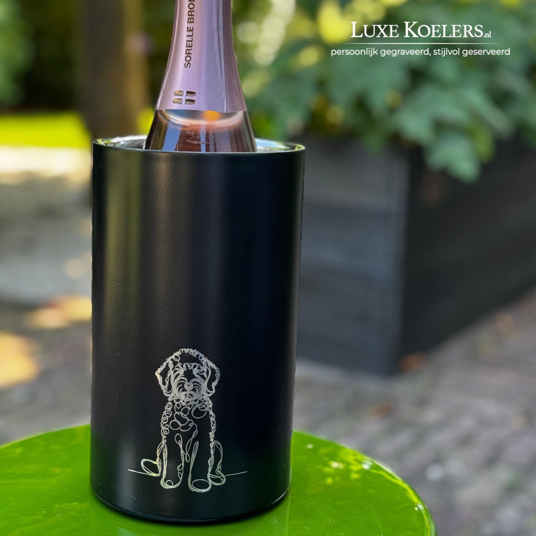 outline van een hond op een mat zwarte koeler op een groene tafel in een tuin