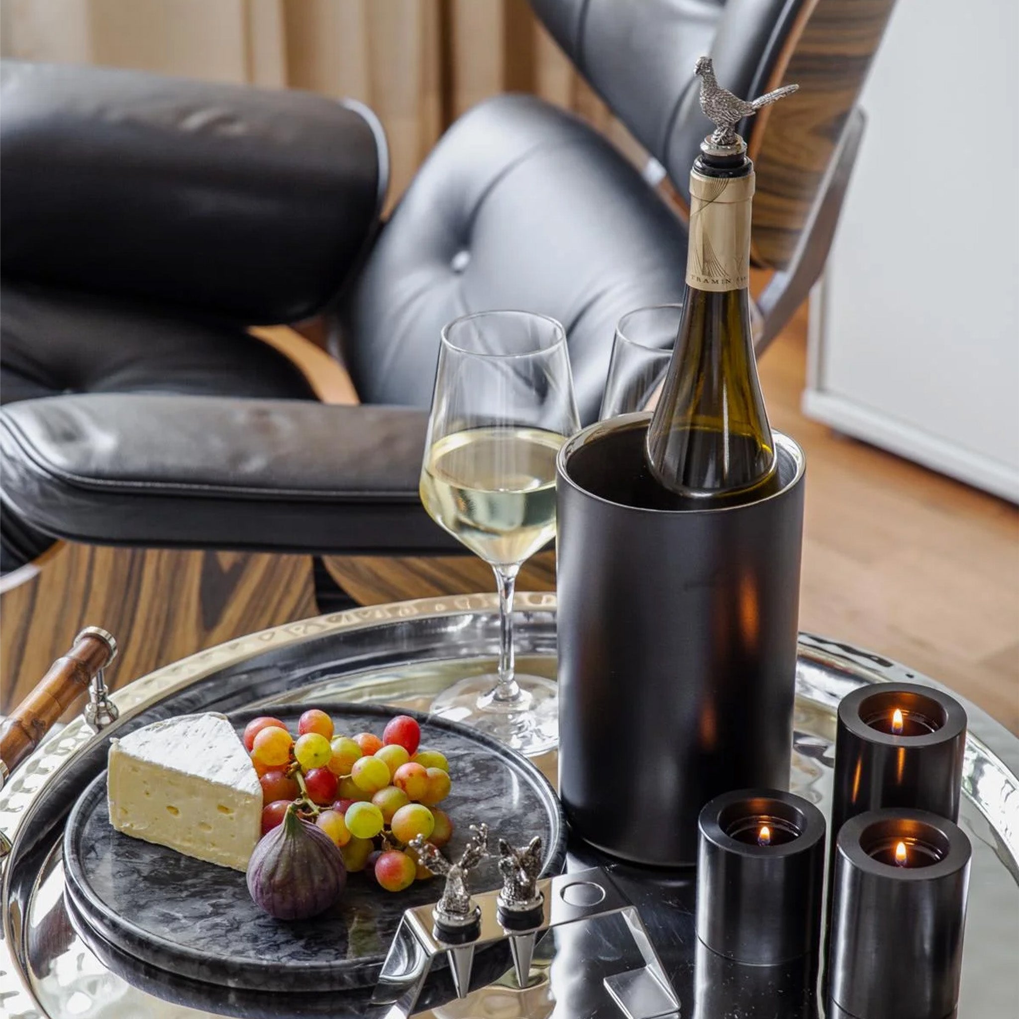 Zwarte koeler op tafeltje met kaarsen en plankje met kaas en fruit