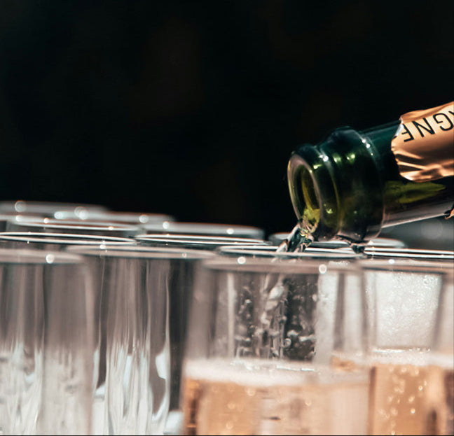 Dienblad met champagneglazen dat wordt ingeschonken